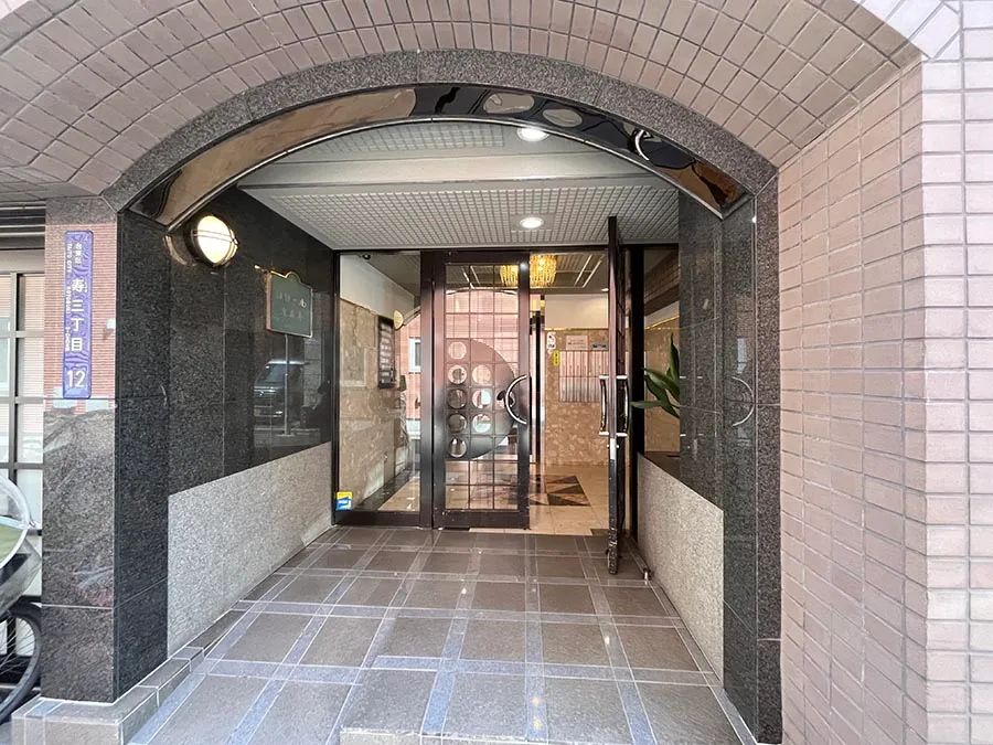 建物の玄関部分（アーチ型の窓枠、ドア、廊下）が主体の写真