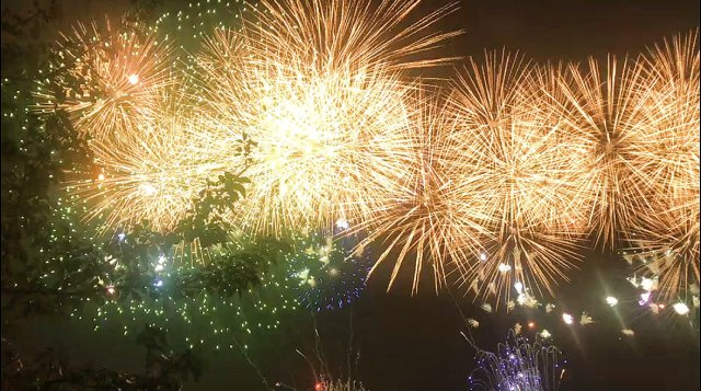 夜空の花火を背景にした窓からの景色が主体の画像