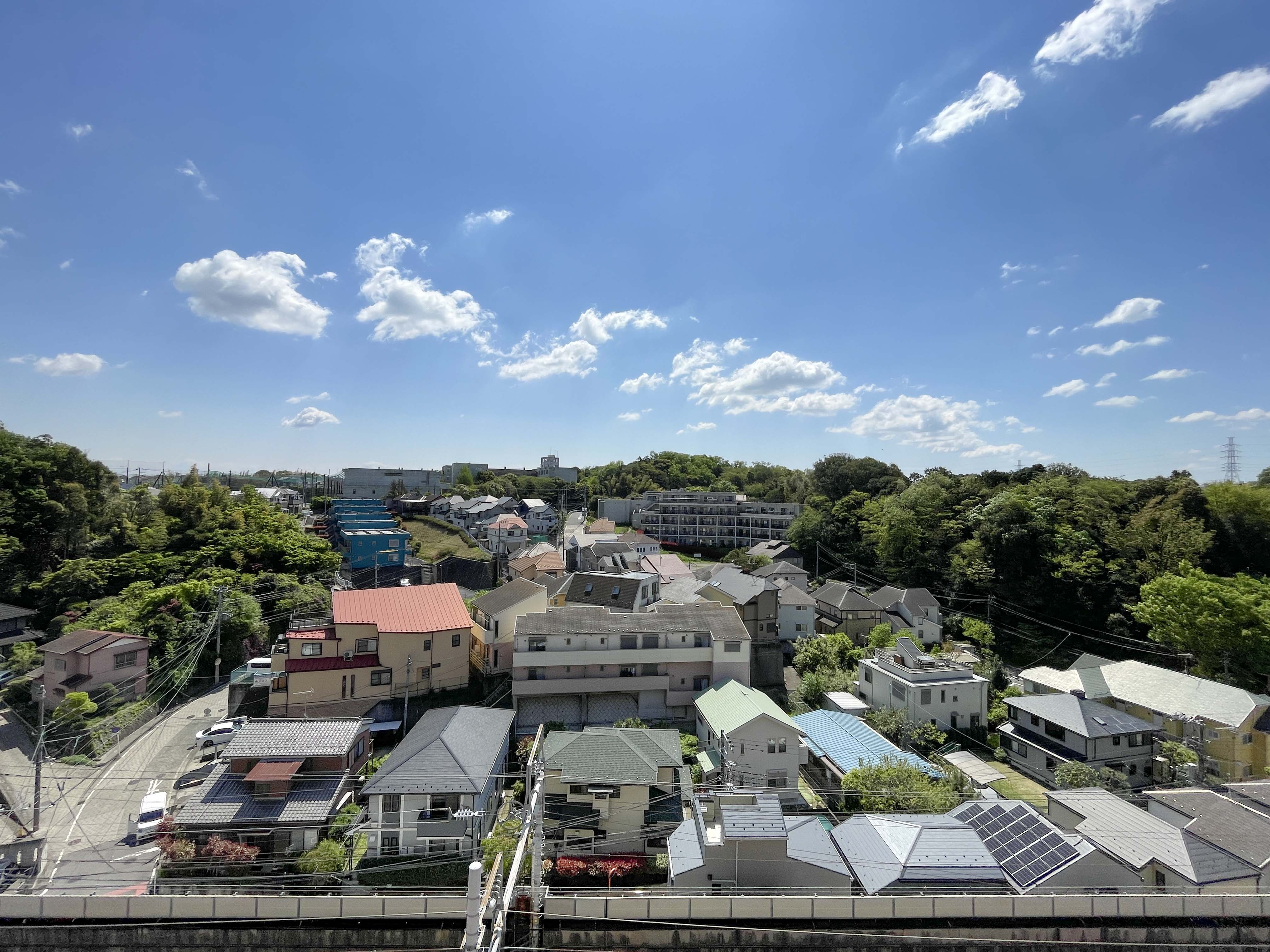 住宅街や道路、自然環境を含む広範な周辺地域の眺望