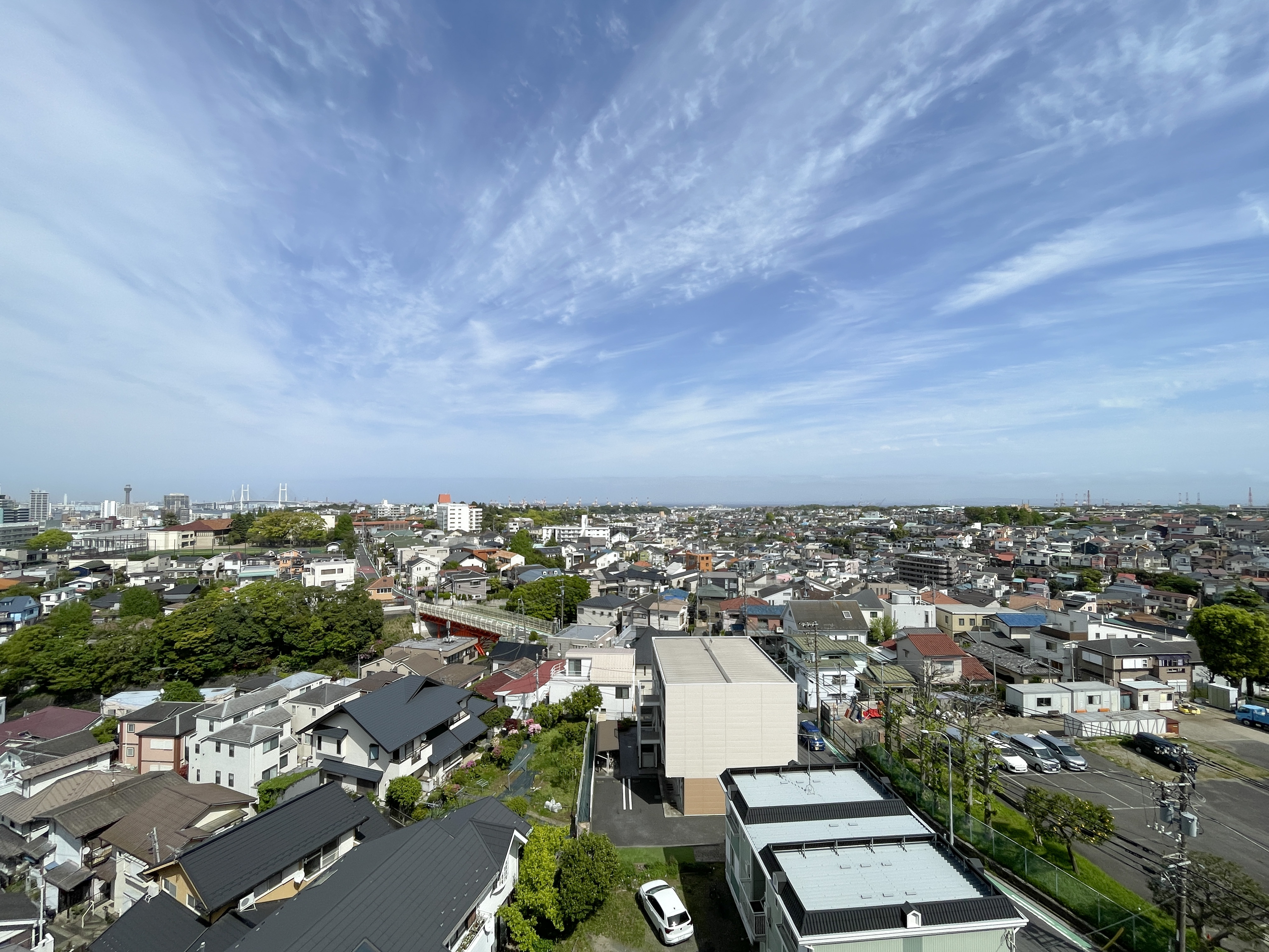 住宅街と道路、遠方の施設を含む周囲の景観