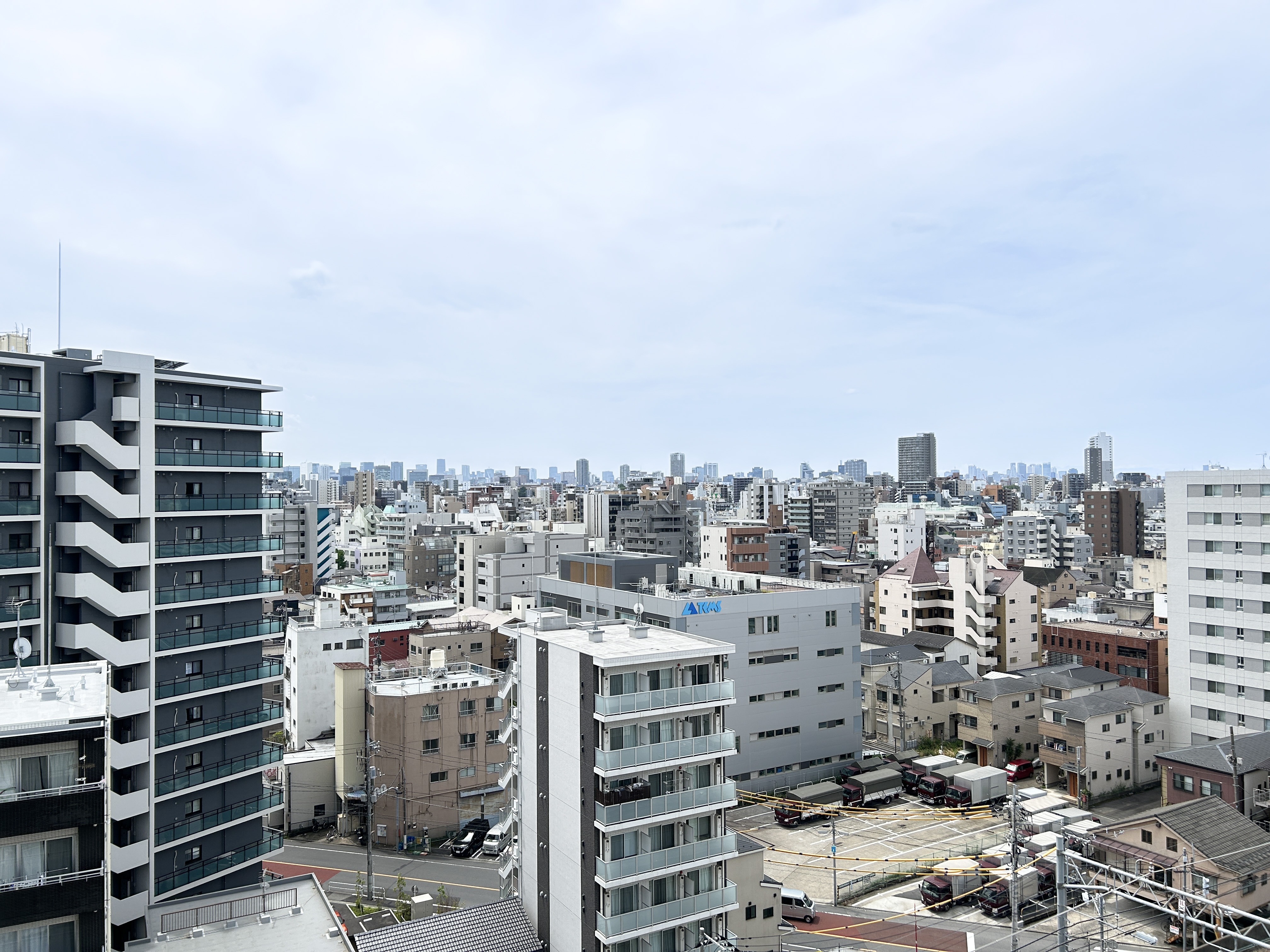 都市部の建物群と道路、駐車場を含む周辺環境を捉えた画像