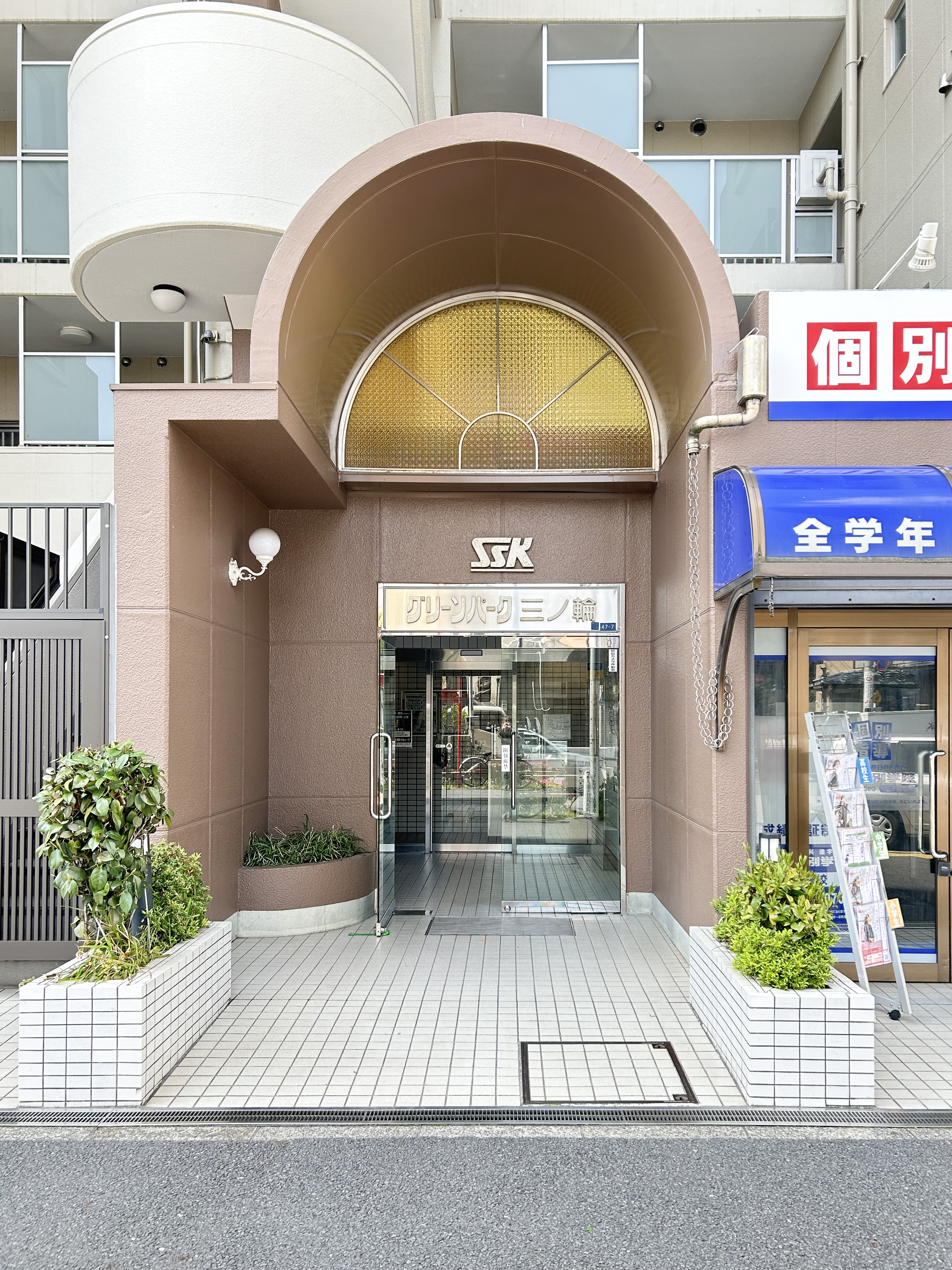 都市部の建物群と道路、駐車場を含む周辺環境を捉えた画像