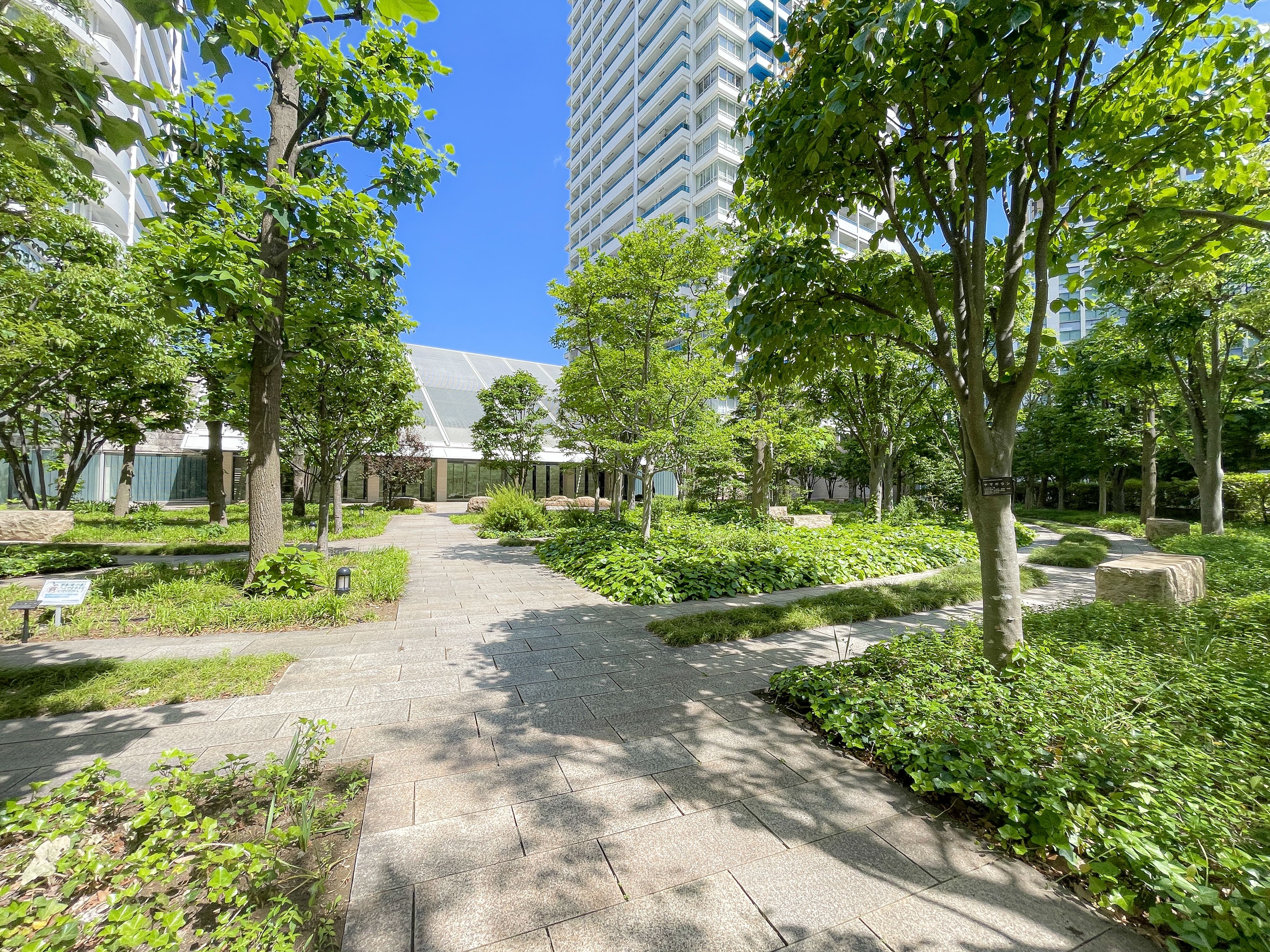 緑豊かな庭園や周辺施設を含む建物の外れの環境を撮影した画像