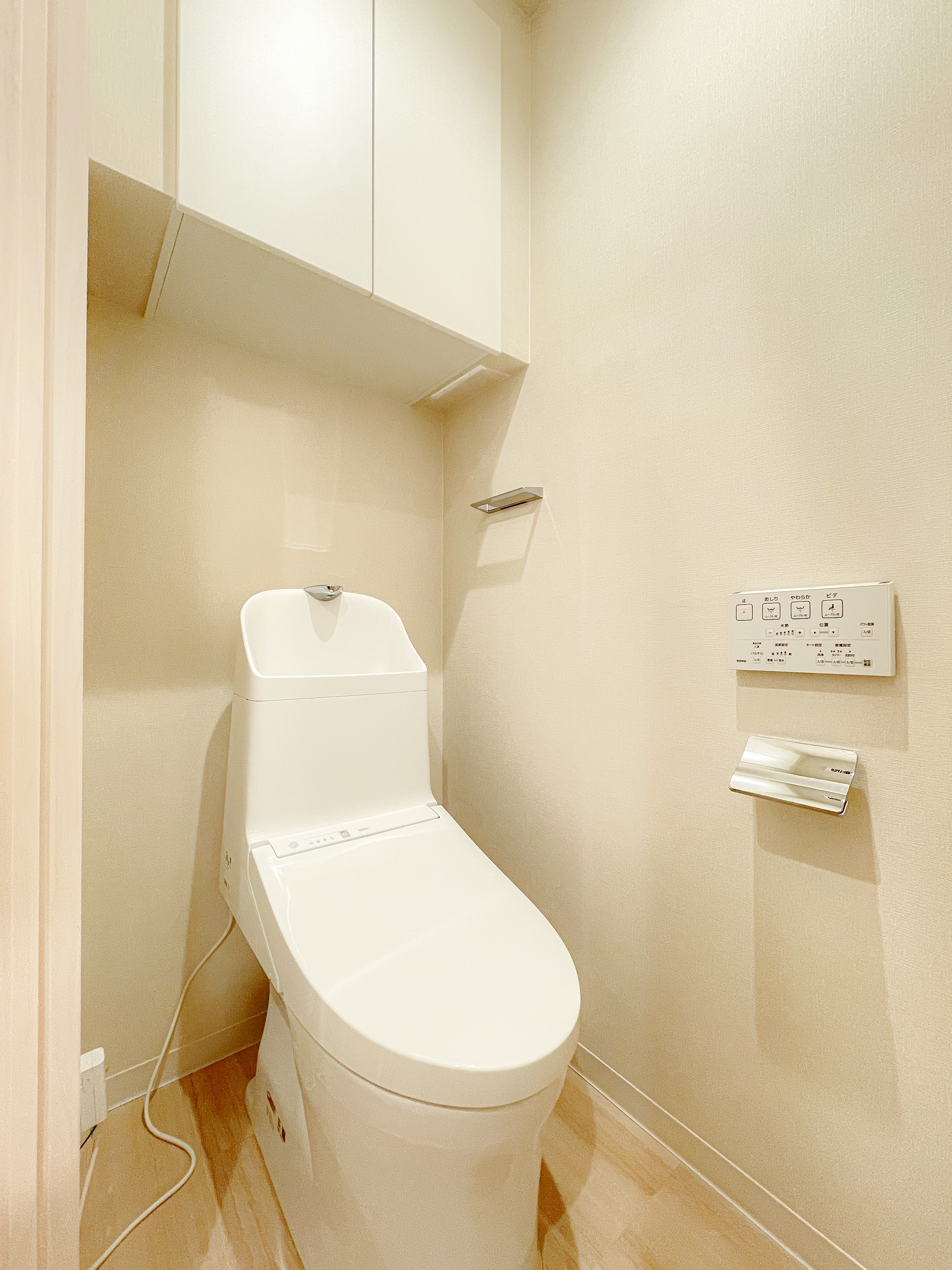 便器とウォシュレットの操作パネルが主体のトイレ室内写真