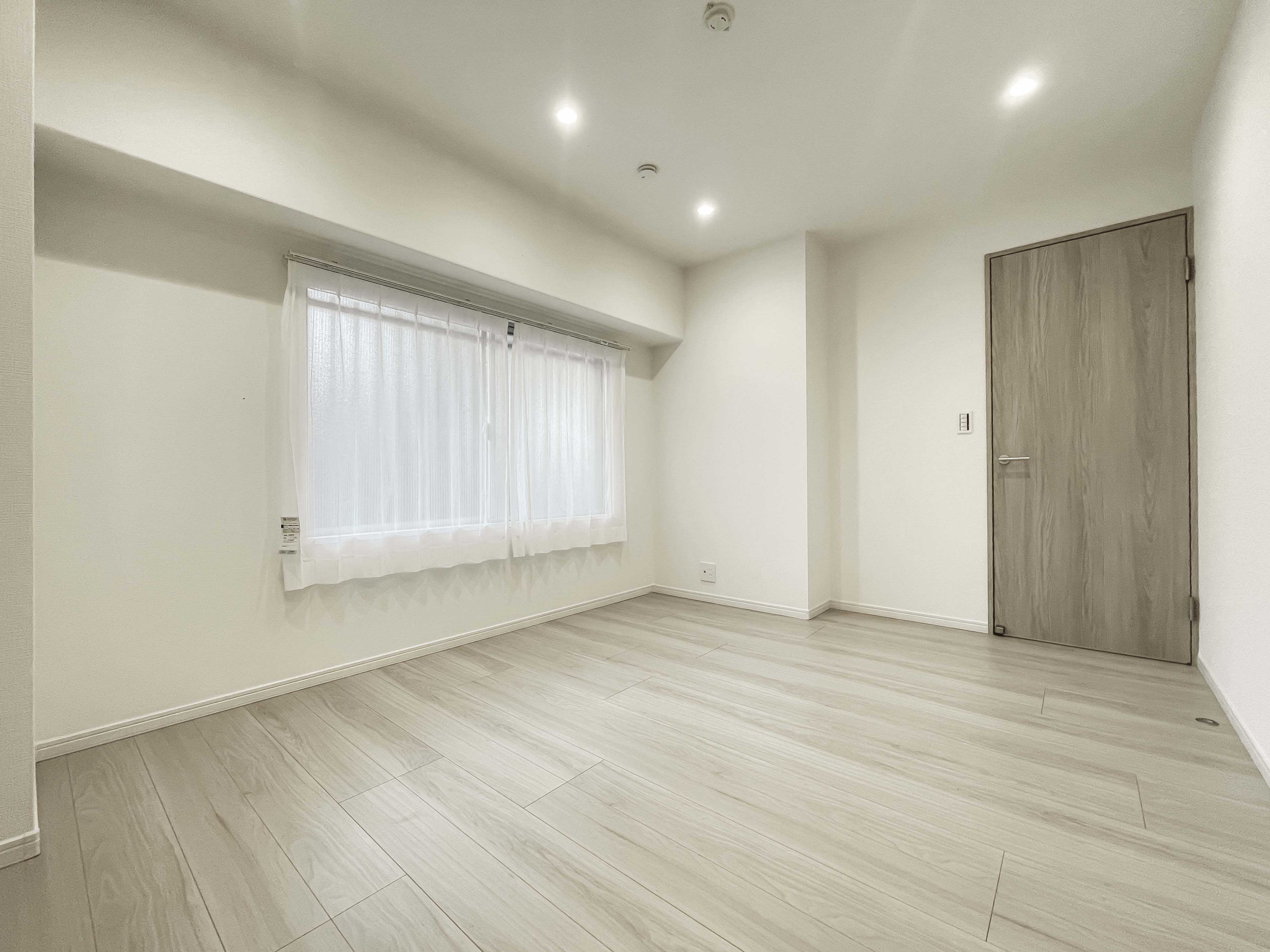 空の部屋で窓とドアが見える洋室の室内写真