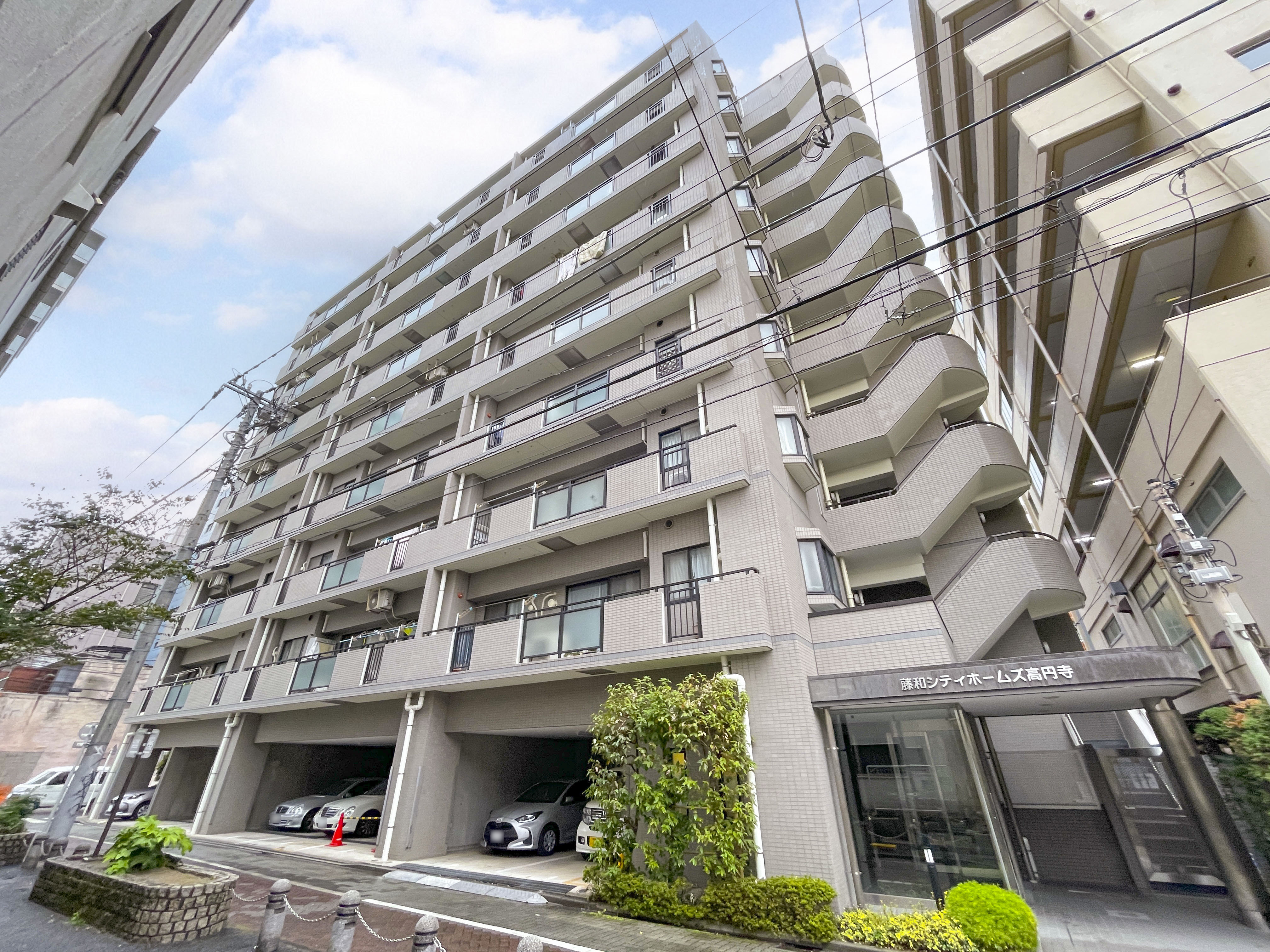 建物の外観全体を撮影した画像で、バルコニー・駐車場・エントランスなどが含まれる