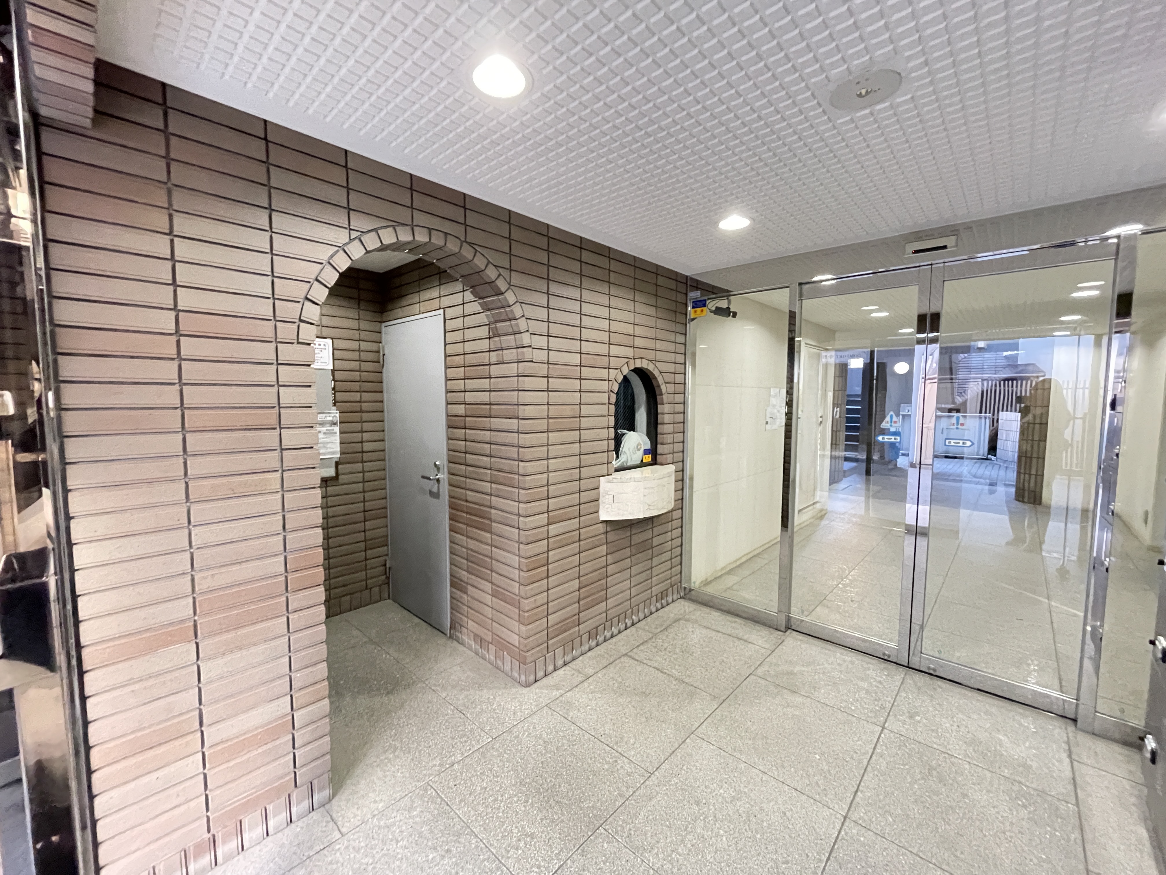 玄関ホールとガラスドアが主体の室内写真