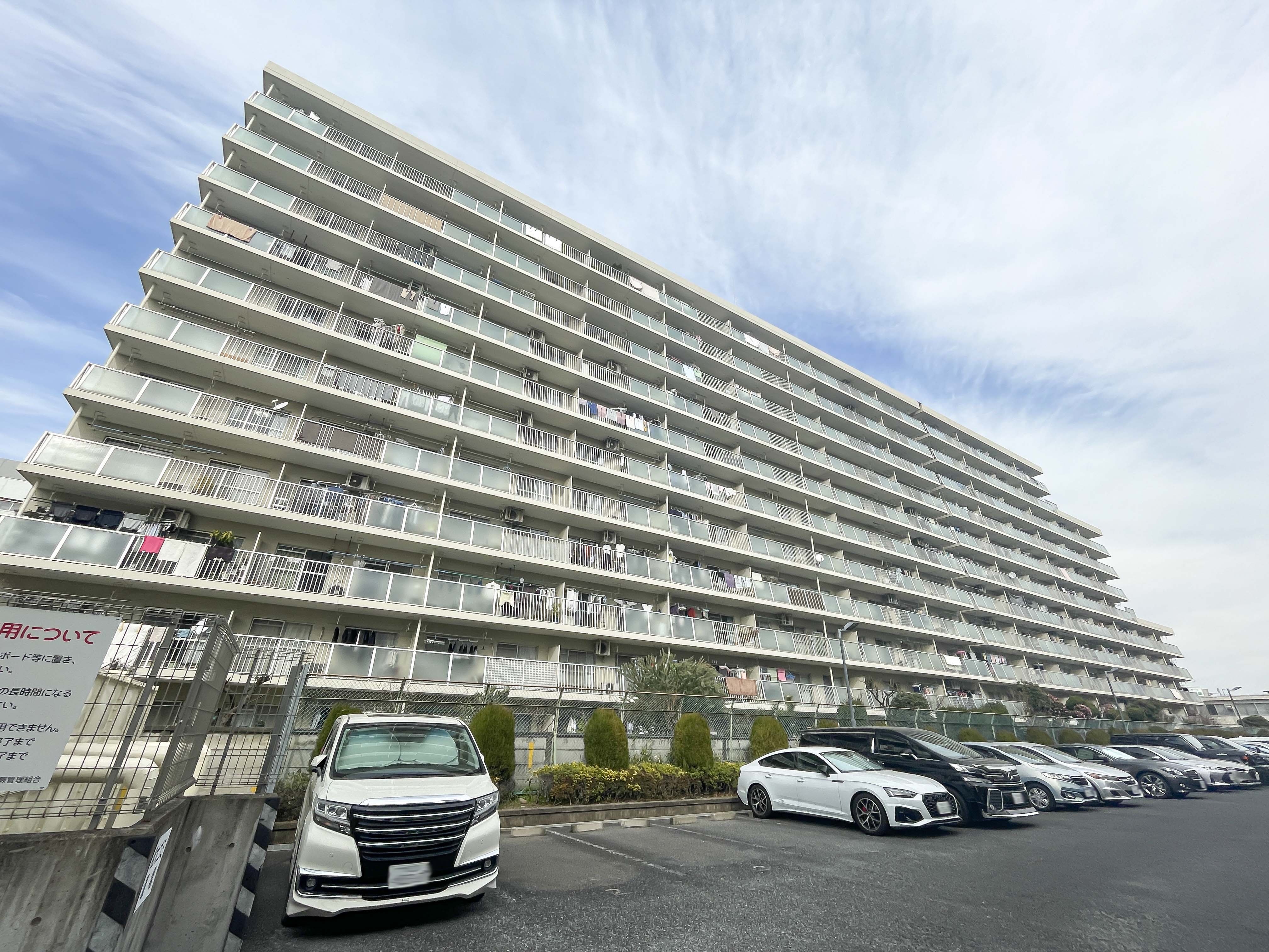 建物の外観全体を捉えた画像で、バルコニーと駐車場が含まれているが、主役は建物の外観
