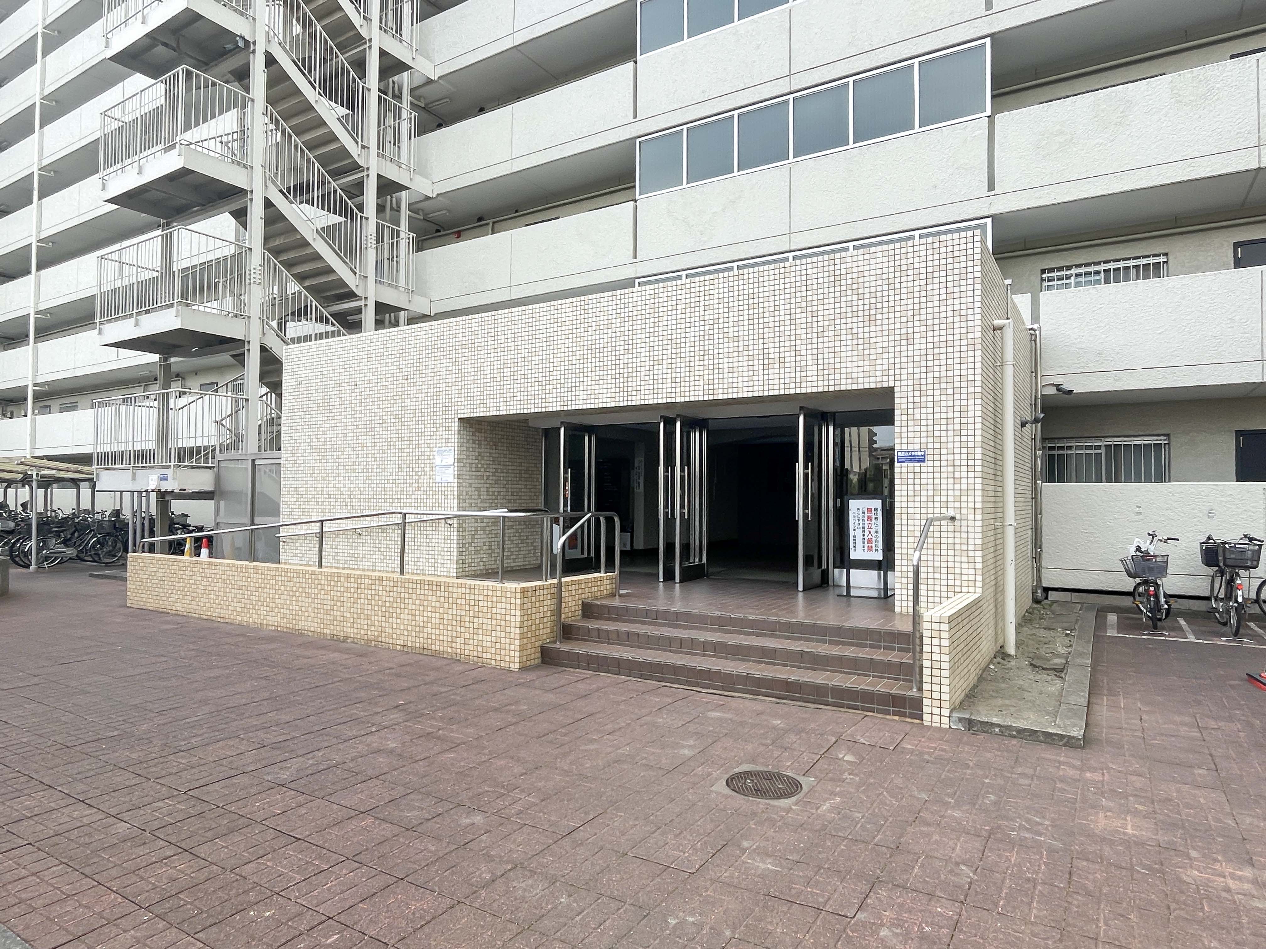 建物の入口部分（階段・ガラスドア・手すり）を主体に撮影した外観