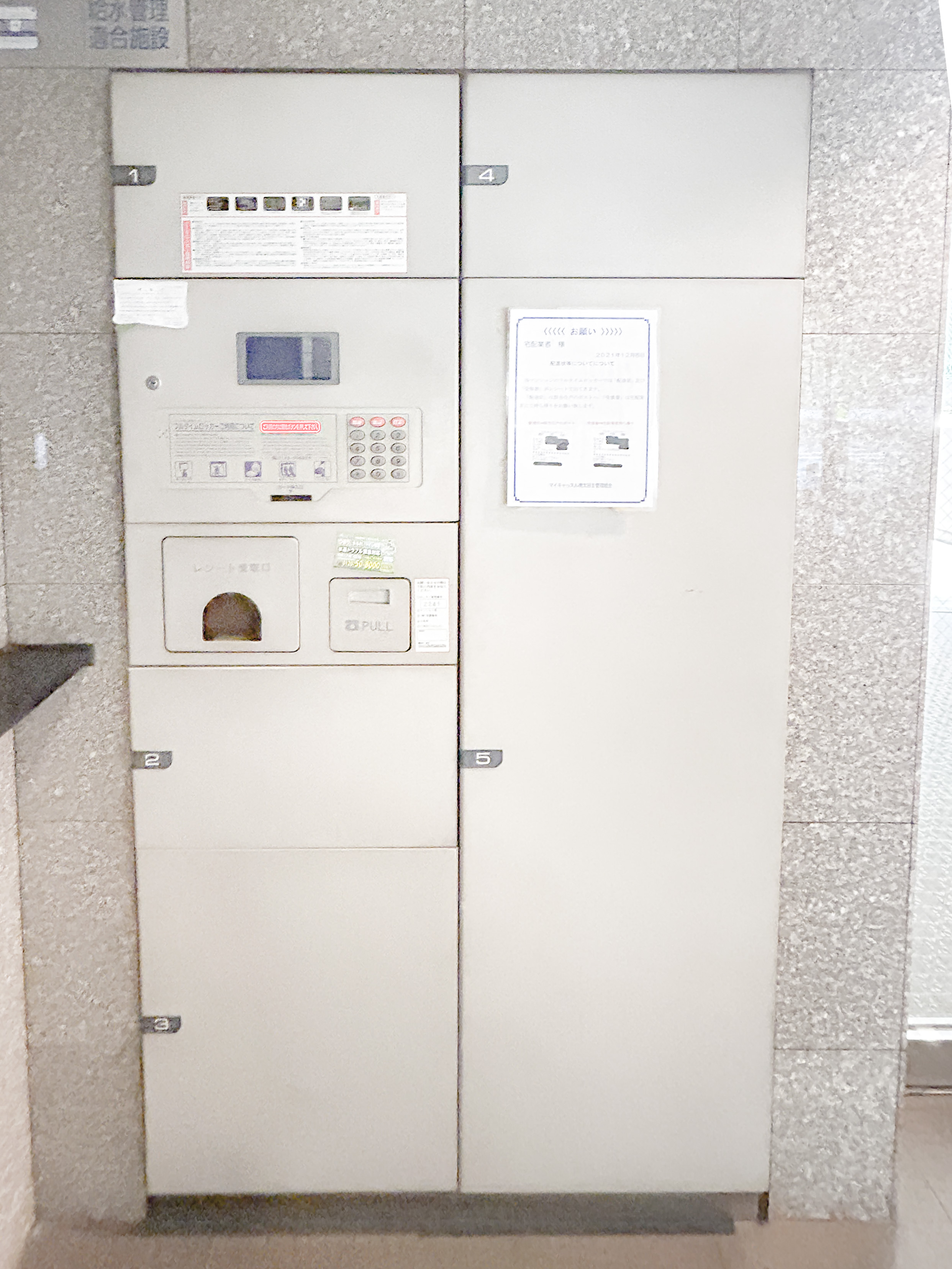 マンションの玄関部分に設置された郵便受けが主体の画像