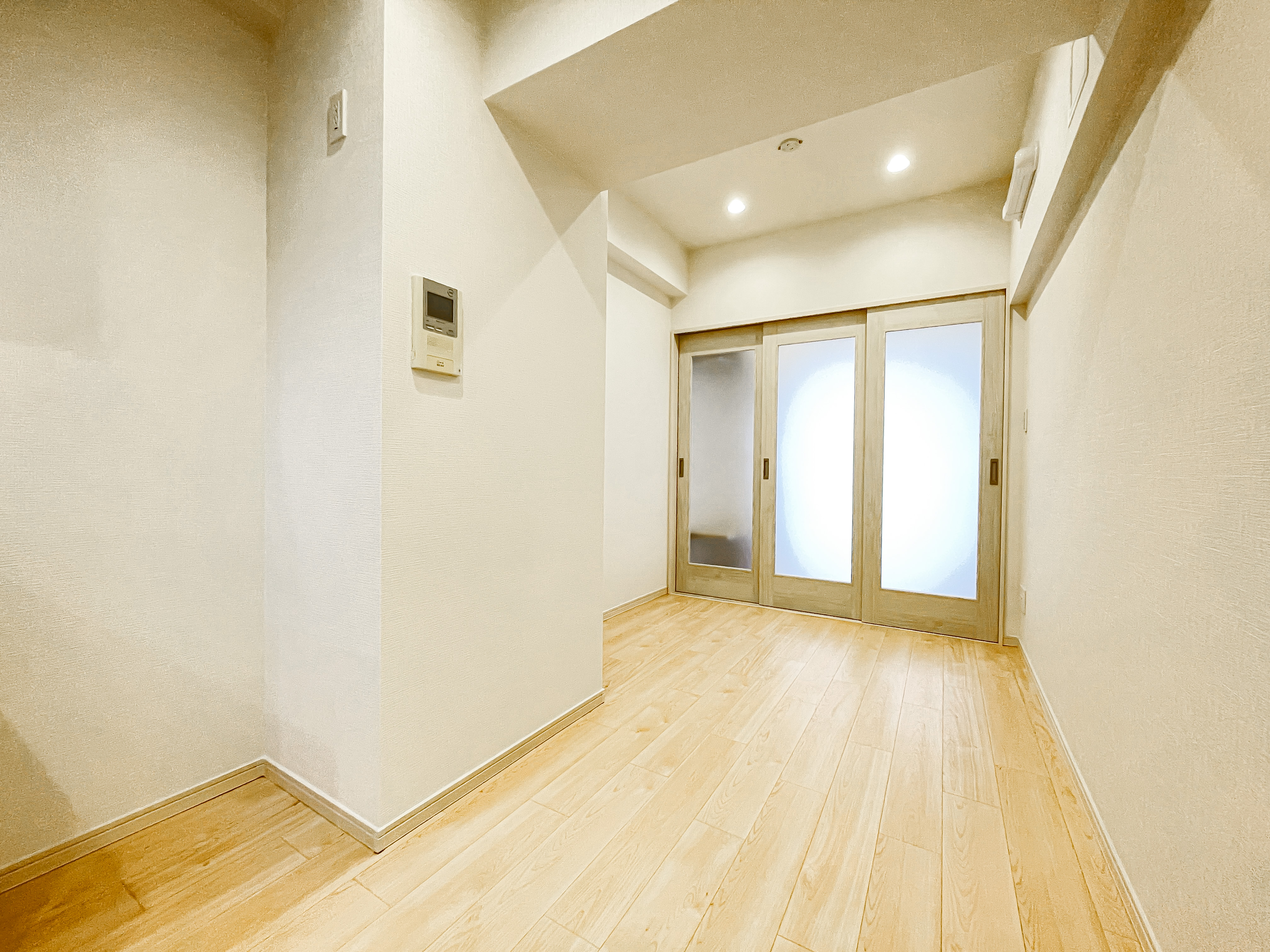 スライドドアで接続された広い空間がリビングエリアの一部として写っている室内写真