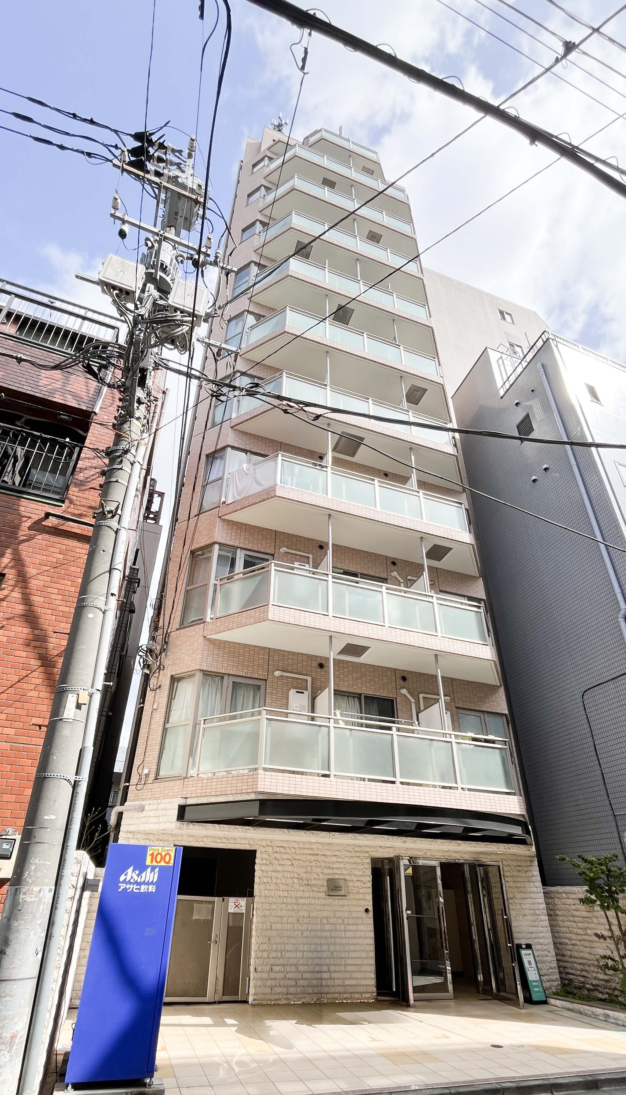 建物の外観全体を捉えた写真で、バルコニー、玄関、周辺環境が含まれる