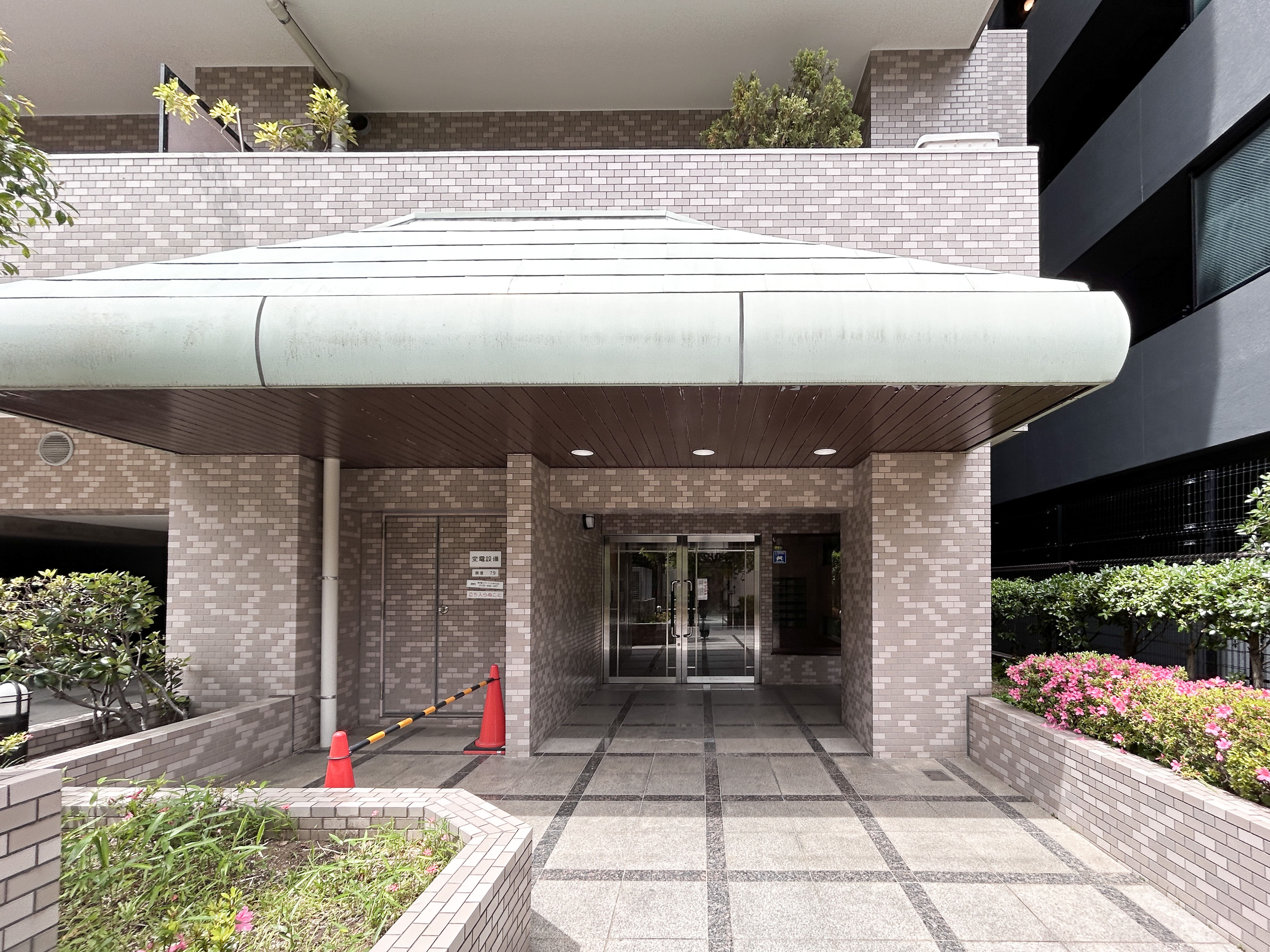 建物の入口部分（アーケード、ガラスドア、周辺の歩道）が主体の外観写真