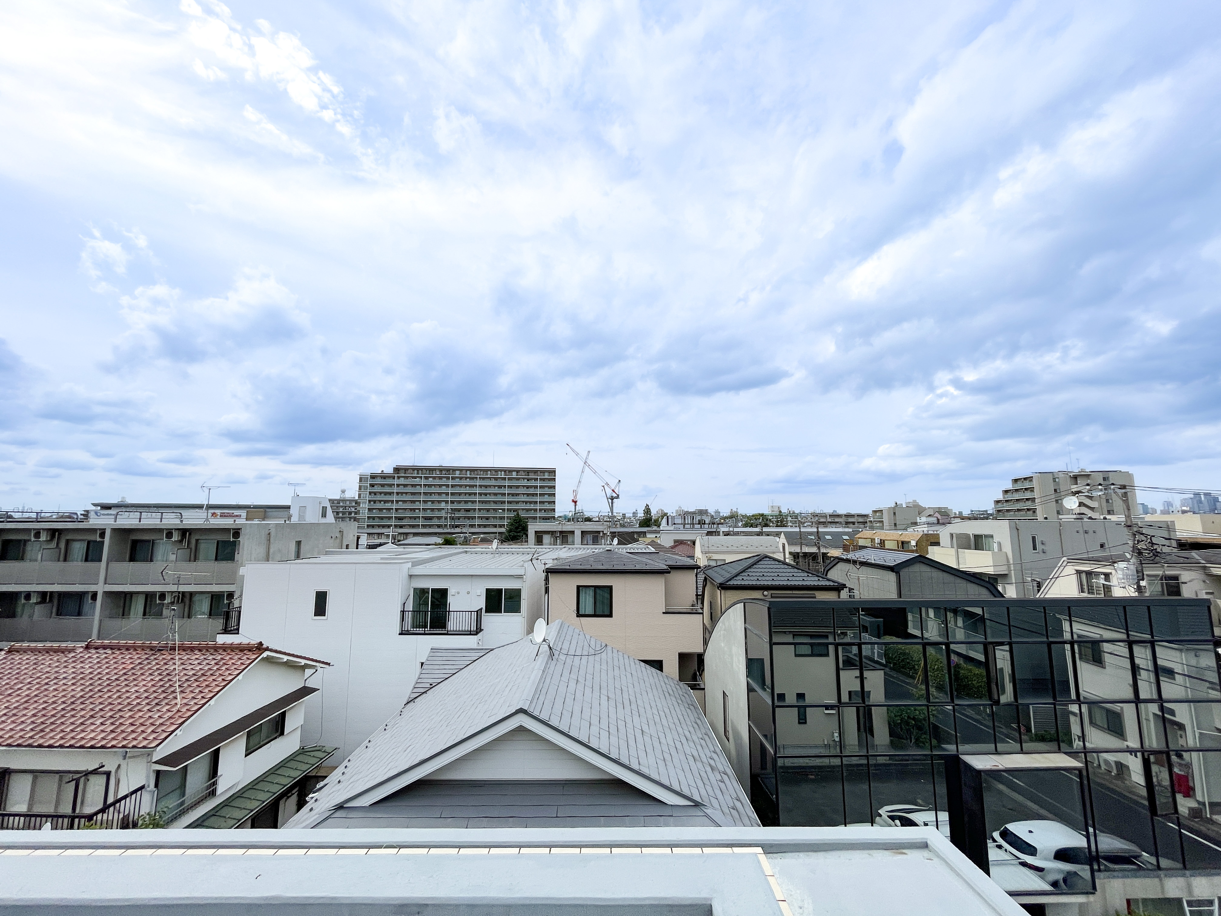 住宅街と道路を含む周囲の環境が主体の写真