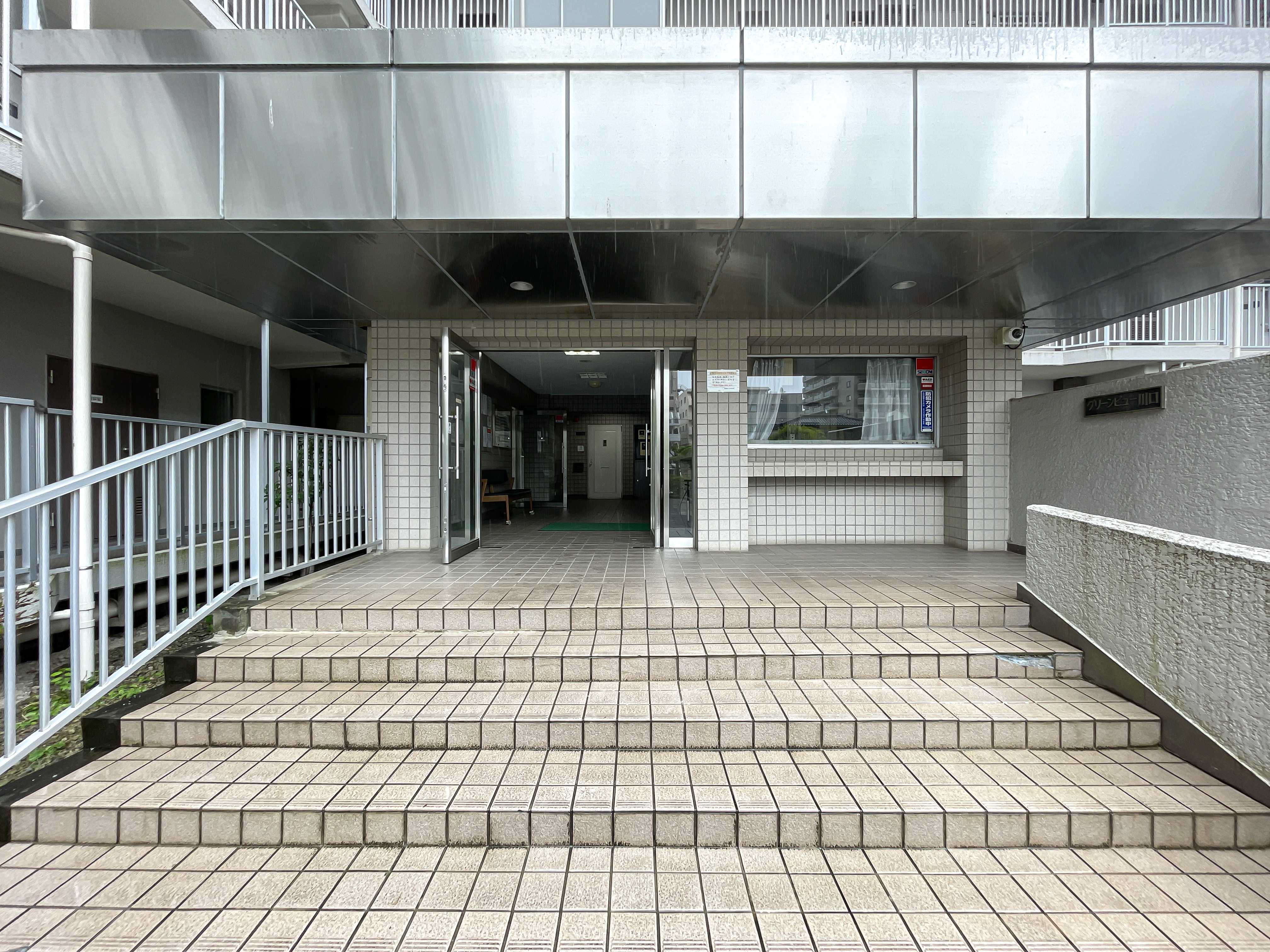 玄関の階段とガラス扉を中心とした外観写真