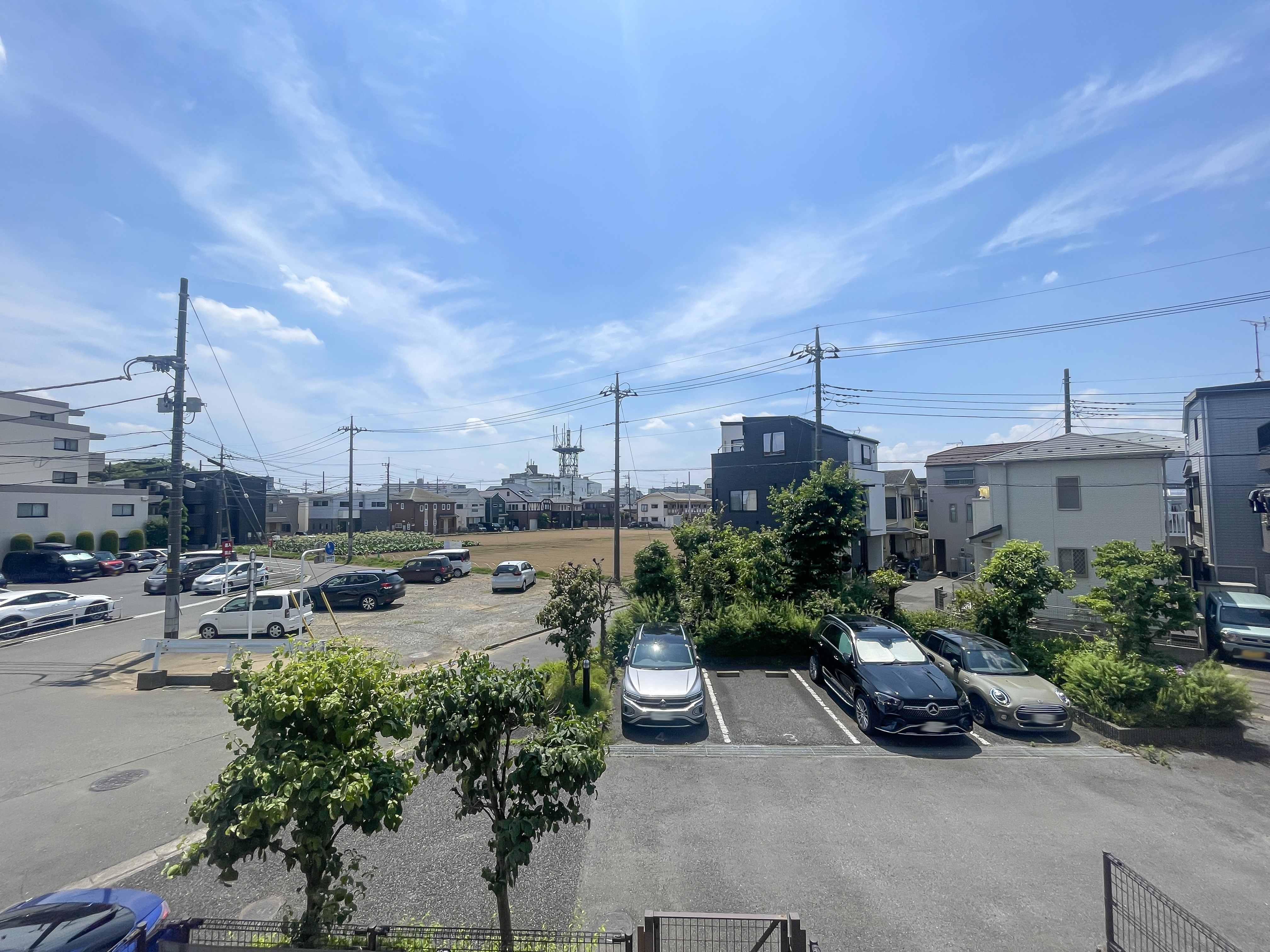 住宅街の道路、駐車場、周辺の建物を含む周囲環境が主体の画像