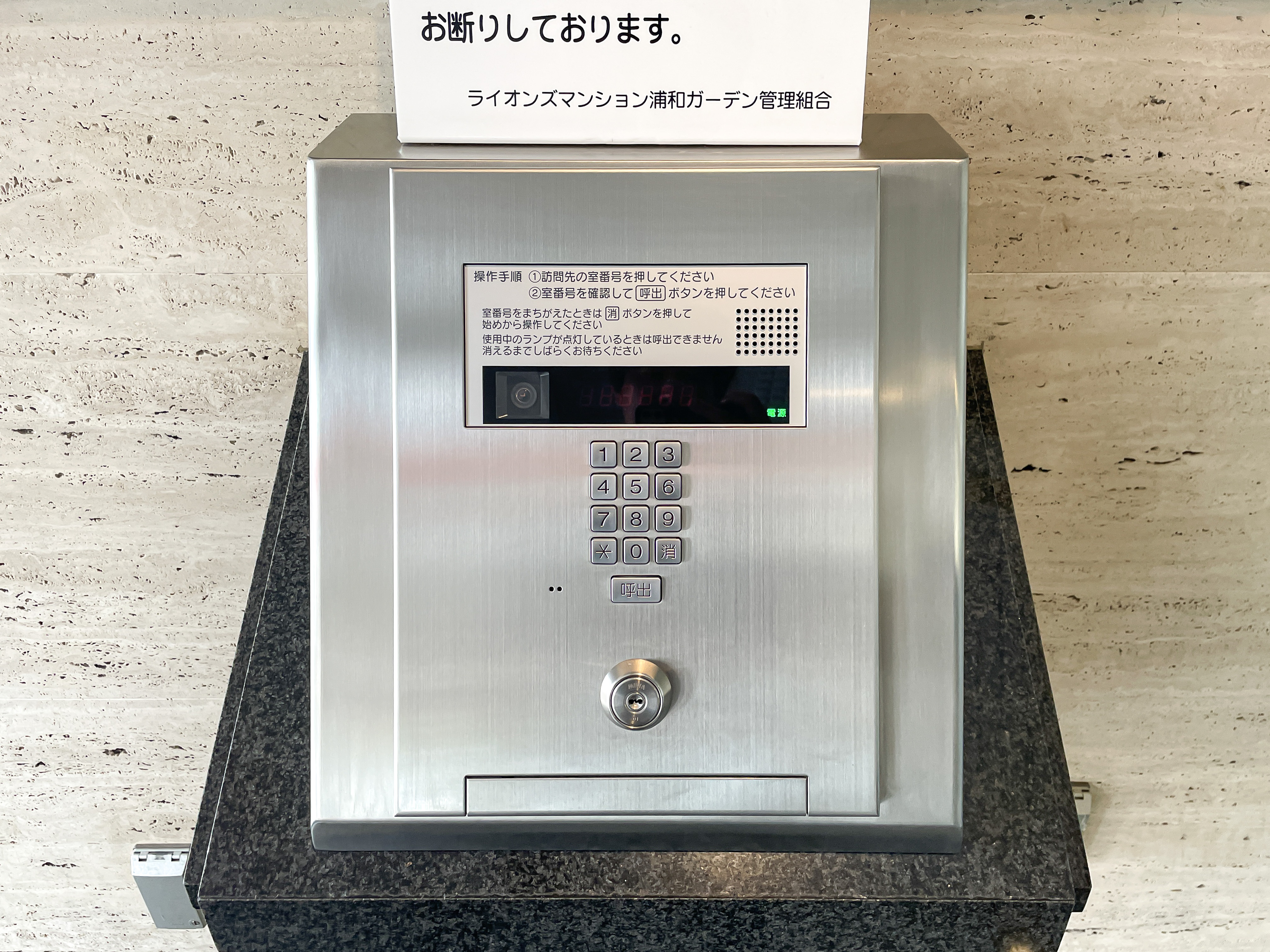 玄関:アパートの玄関に設置された訪問者用インターホンシステムの写真