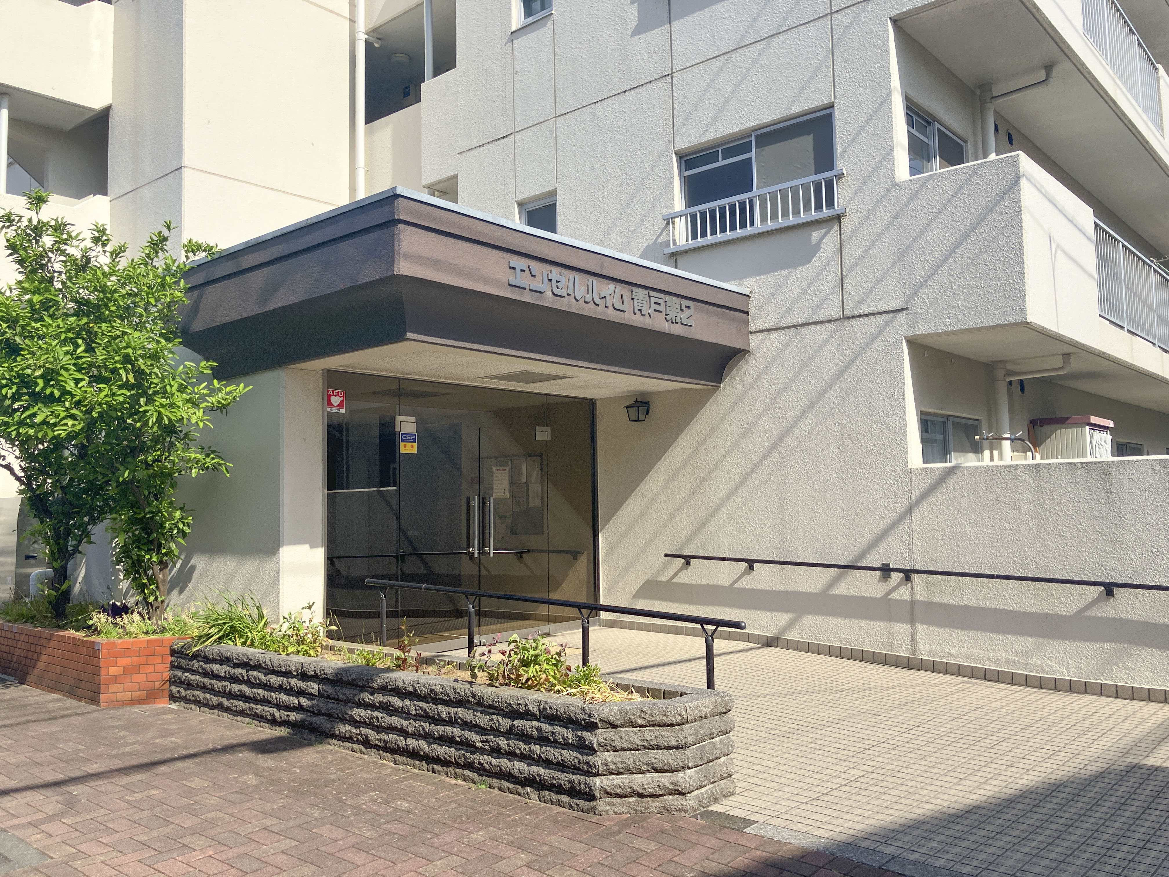 玄関:建物の主要な入り口部分、ガラス扉と屋根付きポーチが主体の画像