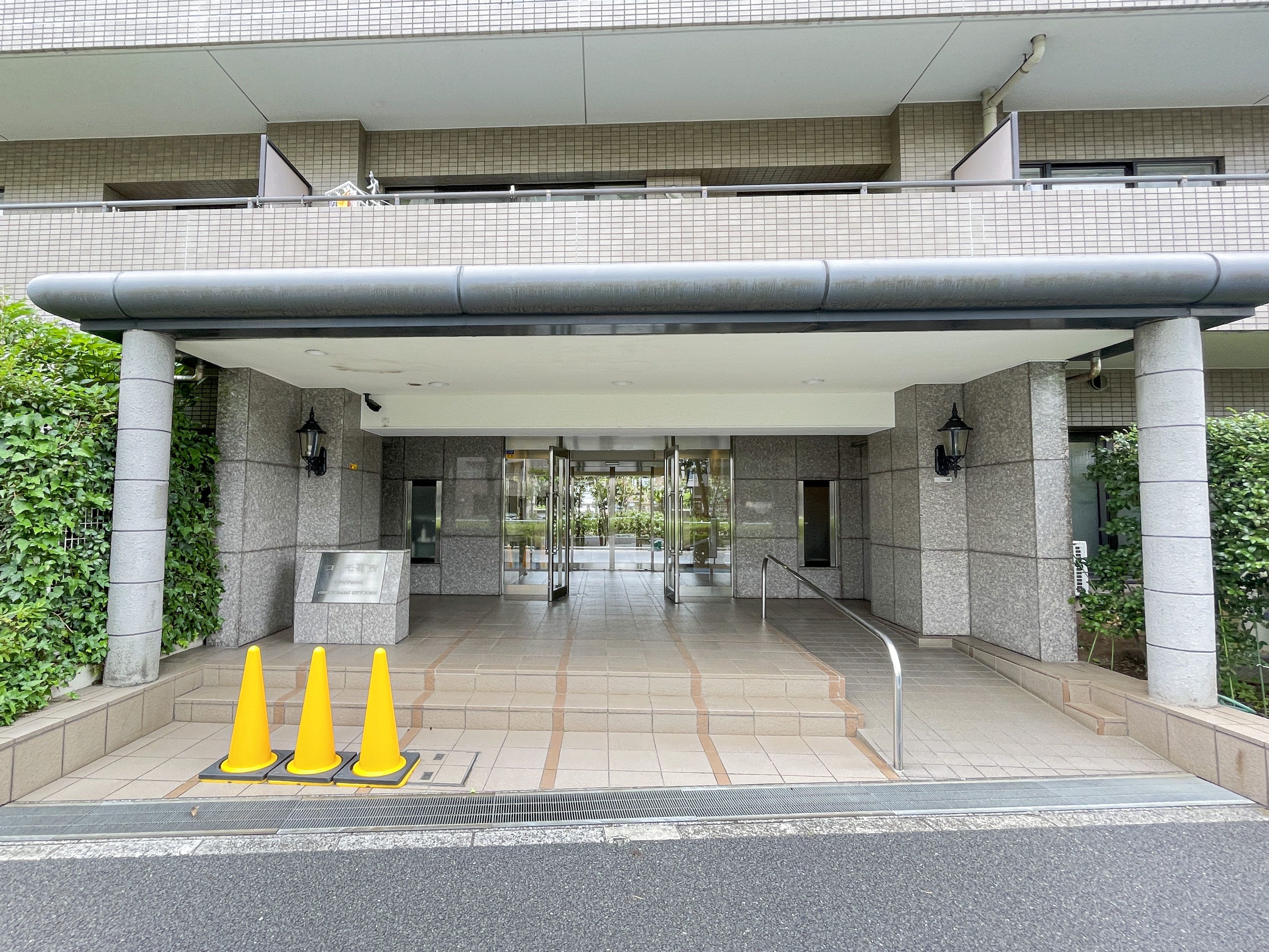 玄関:建物の玄関部分（屋根付きアプローチ、ガラス扉、段差、手すりなど）を主体に撮影した写真