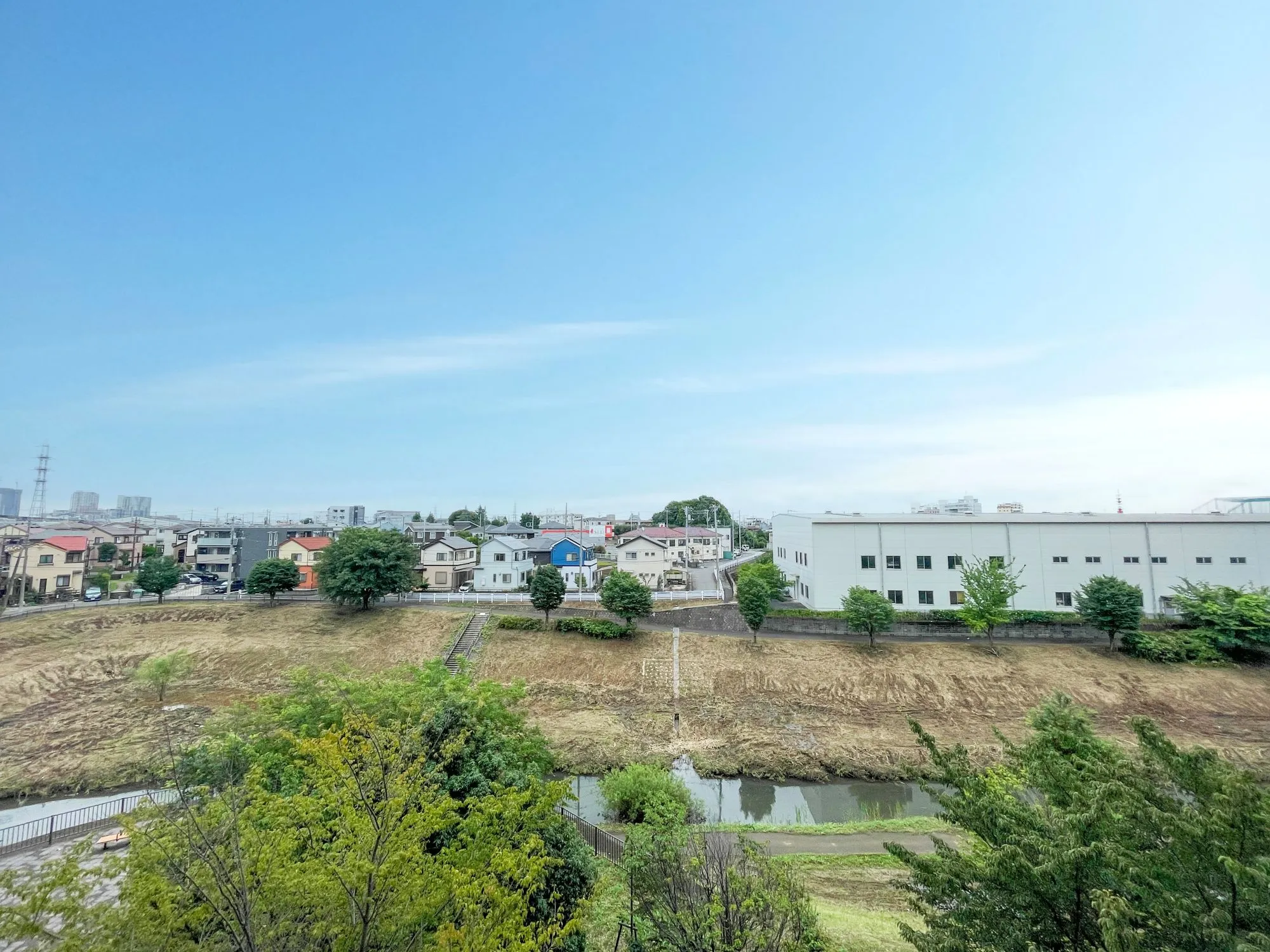 住宅街や道路、河川を含む周辺の風景が主体の画像