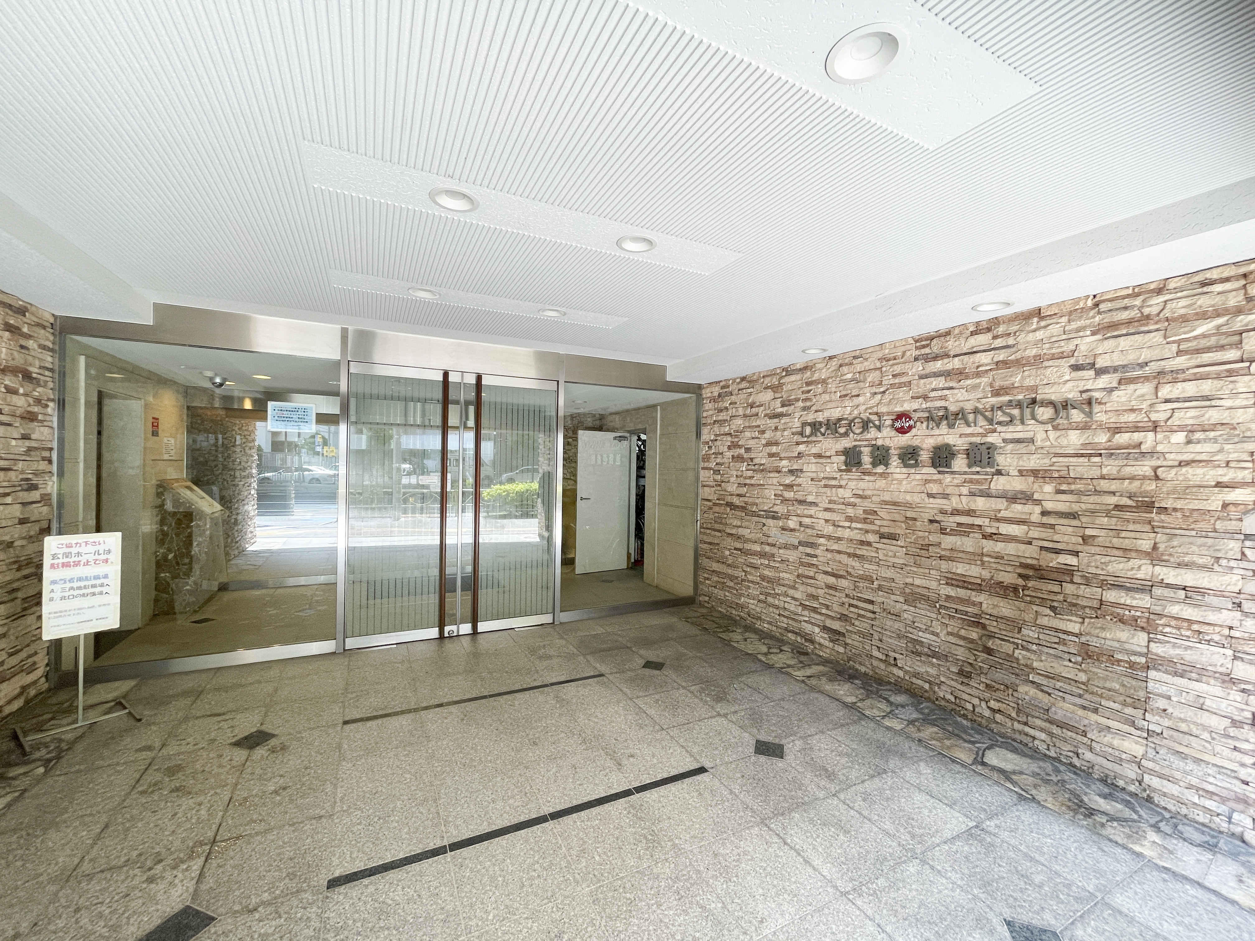 玄関ホールとガラスドアが主体の建物入口写真