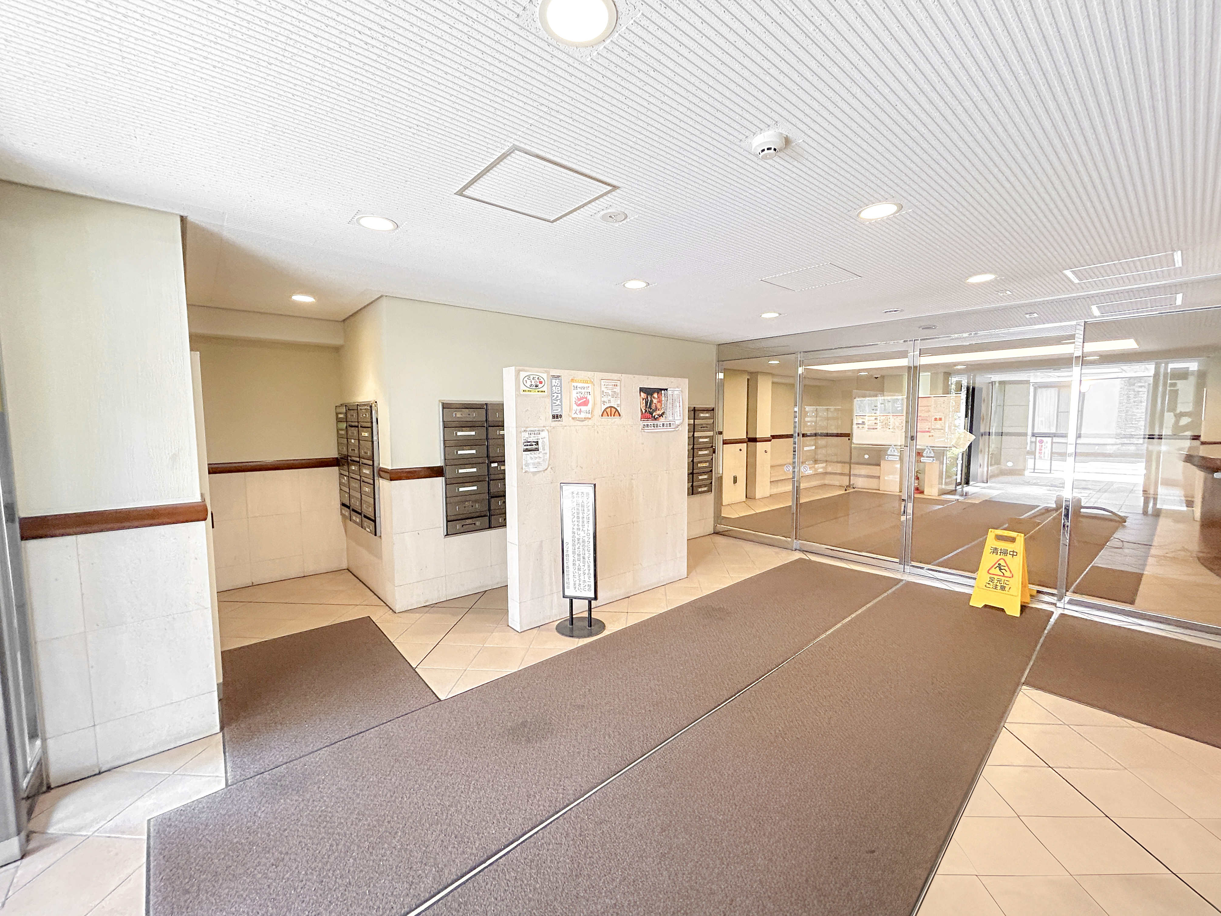 玄関ホールに郵便受けやガラスドアが配置された入口エリアの写真